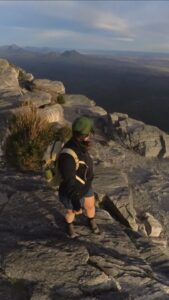 Midsize hiker standing on cliff edge wearing Zorali Women’s Rugged Recycled Shorts