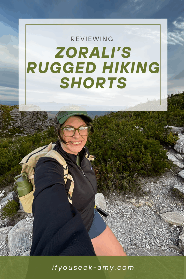 Pinterest graphic for a Zorali Women’s Rugged Hiking Shorts review featuring a midsize hiker smiling on a rocky trail, wearing the shorts with a backpack and cap, overlaid with the blog title “Reviewing Zorali’s Rugged Hiking Shorts” and website URL ifyouseek-amy.com