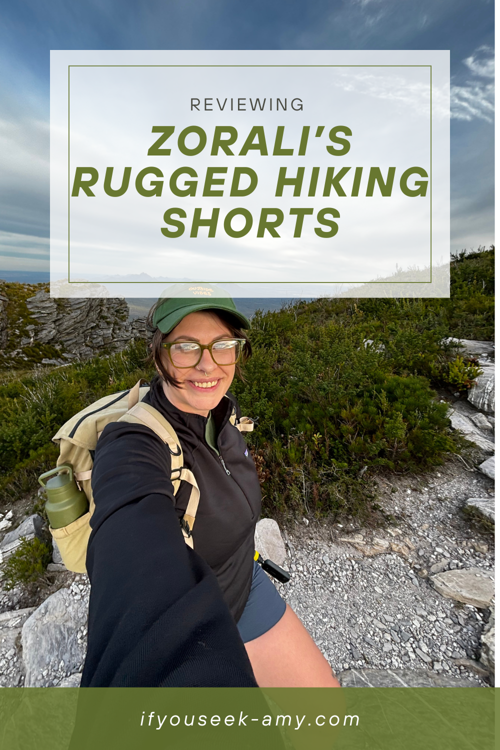 Pinterest graphic for a Zorali Women’s Rugged Hiking Shorts review featuring a midsize hiker smiling on a rocky trail, wearing the shorts with a backpack and cap, overlaid with the blog title “Reviewing Zorali’s Rugged Hiking Shorts” and website URL ifyouseek-amy.com